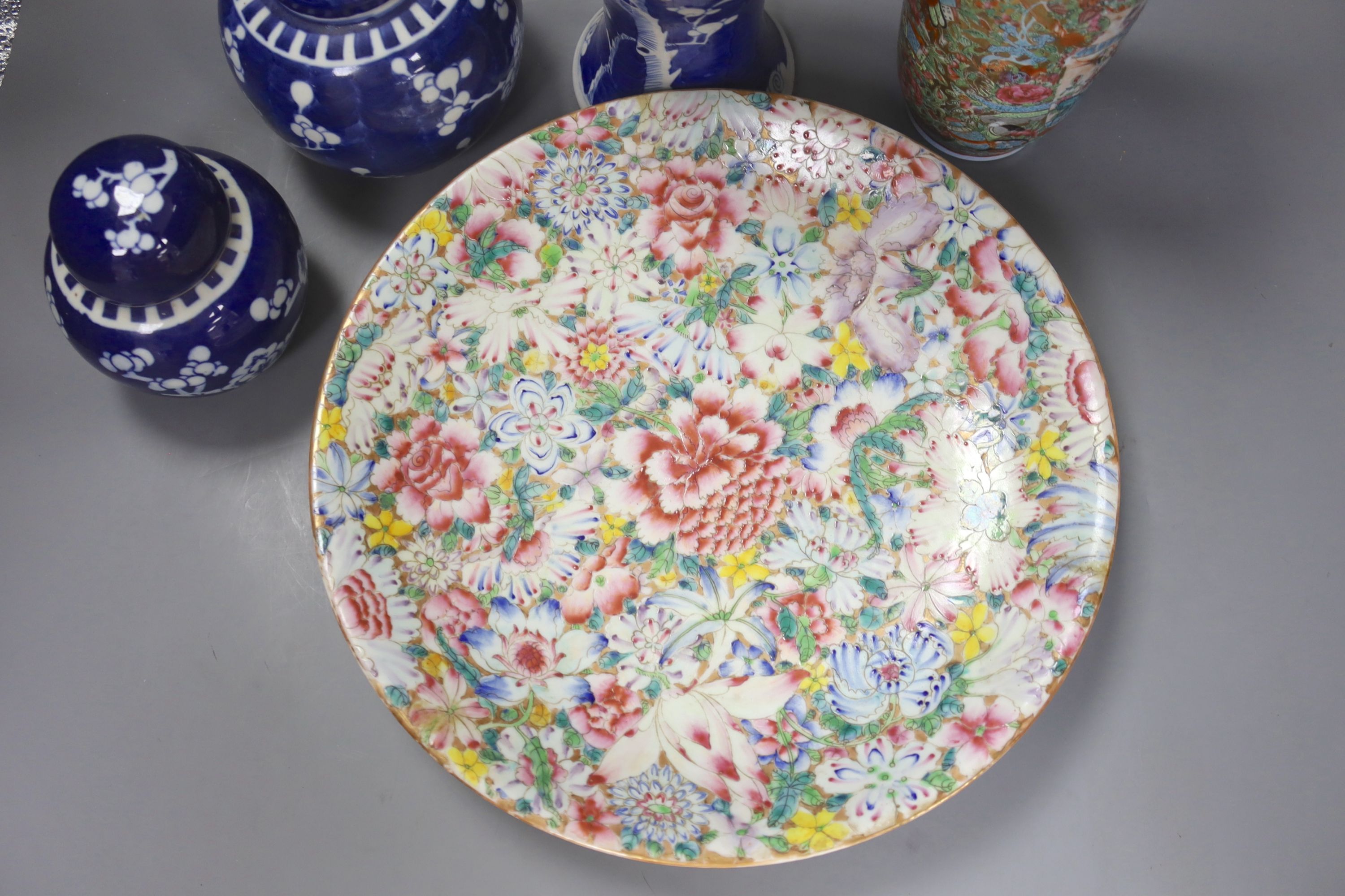 An early 20th century Chinese blue and white ‘prunus’ vase a Republic period millefleur dish, a similar Canton vase and two blue and white jars
